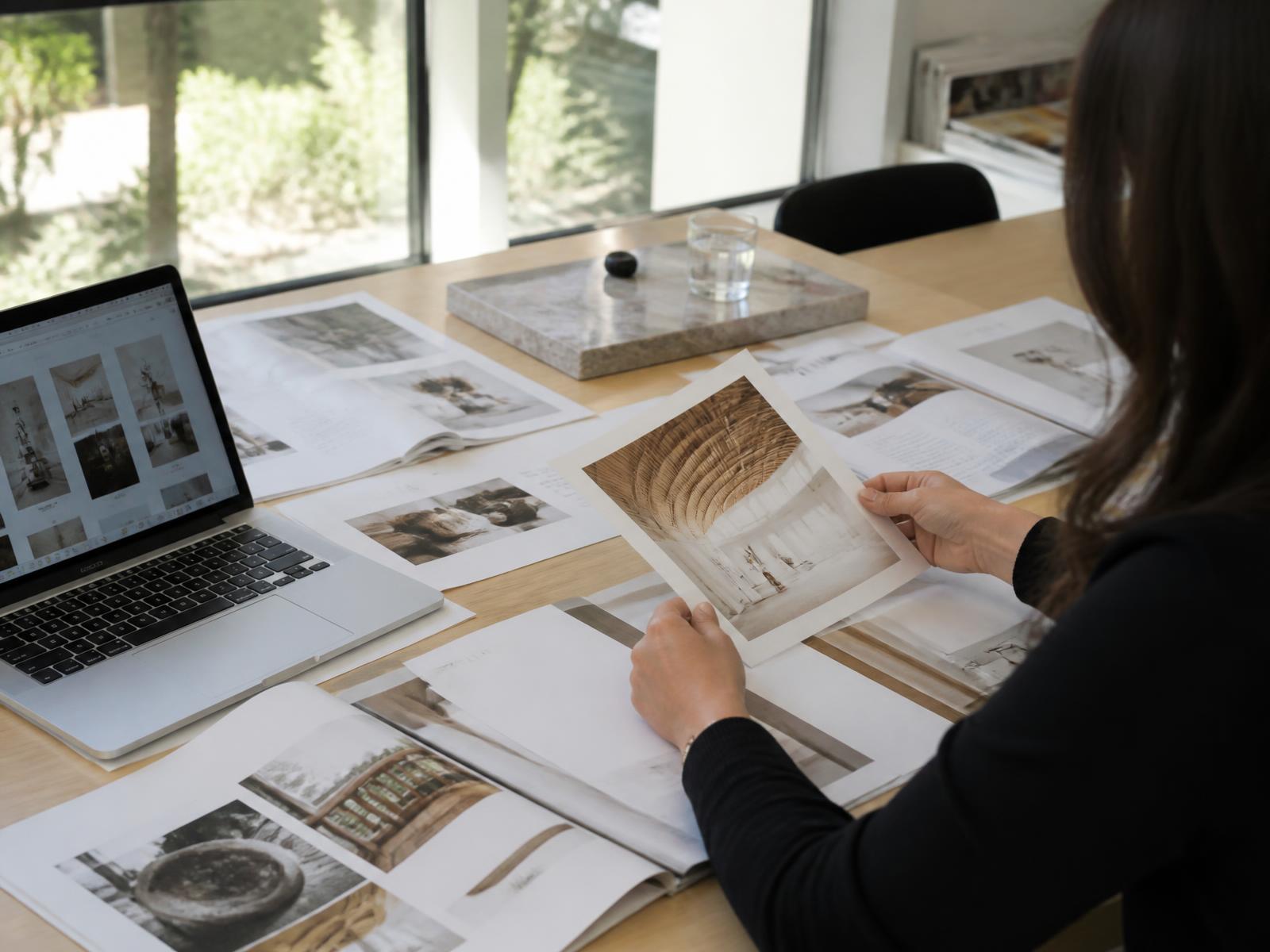 Marketingtisch mit ausgedruckten Layouts und Fotos im Tageslicht